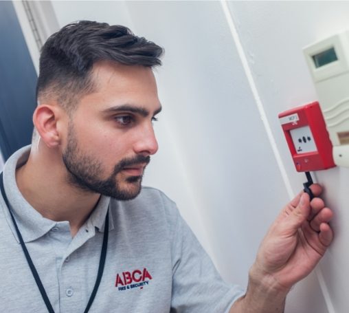 Engineer testing a fire alarm call point