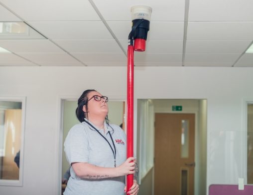 Engineer testing a smoke detector